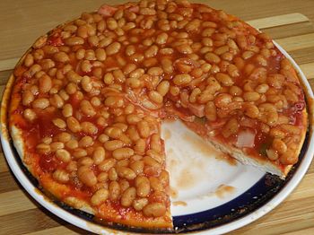 фото вкусной пиццы с фасолью на тарелке в разрезе