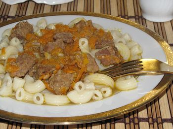 фото вкусного тушеного в кастрюле мяса с овощами на тарелке