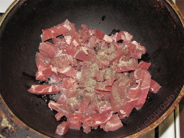 Поместить нарезанное мясо в казан и обжарить на слабом огне