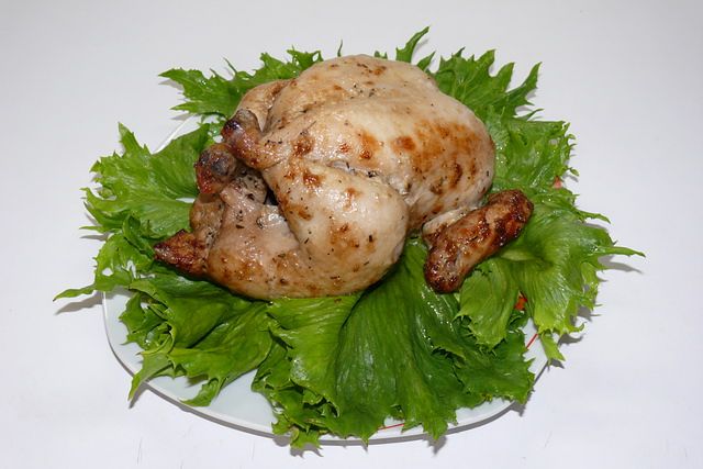 Курица-гриль на вертеле в духовке. Фото готового блюда с овощами и свежей зеленью