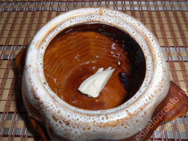 На дно керамического горшочка кладем кусочек сливочного масла