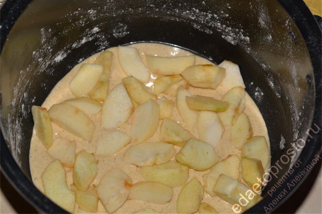 Вылить в чашу половину теста для шарлотки и распределить яблоки