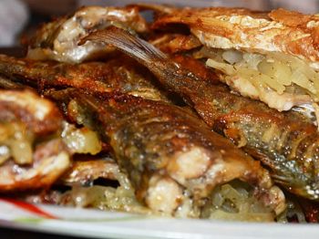 жареная на сковороде рыба с картошкой на тарелке