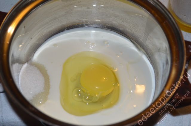 В кастрюлю вылить кефир, разбить яйцо, добавить сахар