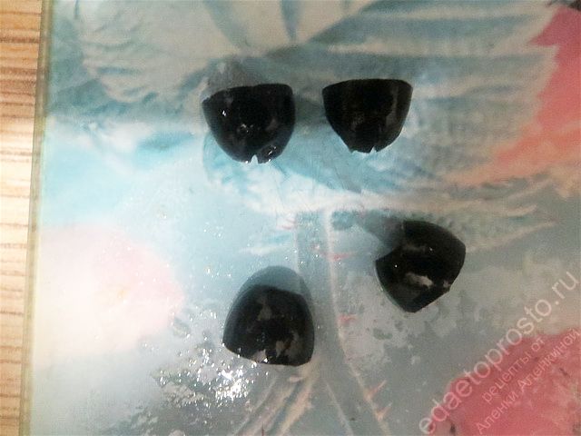 Черные оливки разрезаем на четыре части