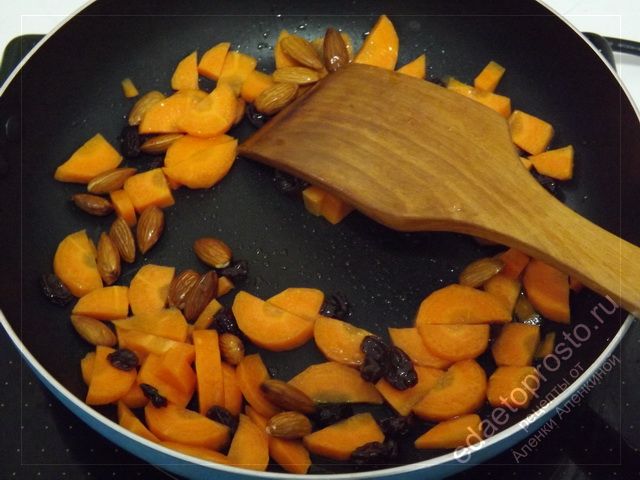 поджарьте морковь вместе со смесью специй, миндальными орехами и изюмом