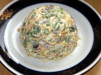 Фото вкусного салата с грибами и фасолью горкой на тарелке