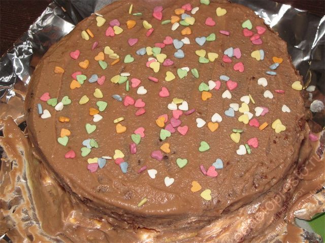 Посыпать верхнюю часть торта для украшения кондитерской посыпкой. пошаговое фото приготовления торта Сникерс