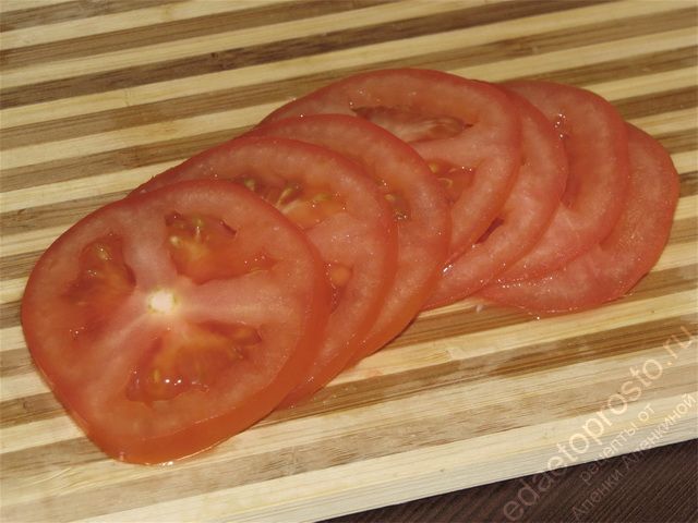 Помыть помидор и нарезать его тонкими ломтиками