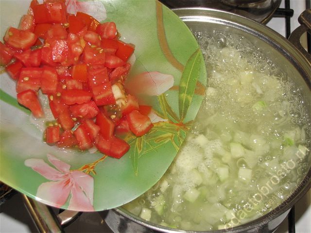 Положить нарезанный помидор в кастрюлю