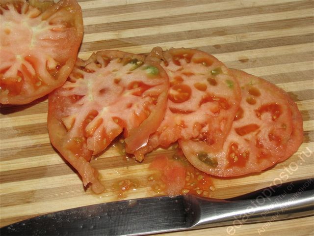 Помыть помидоры и нарезать их тонкими кружочками