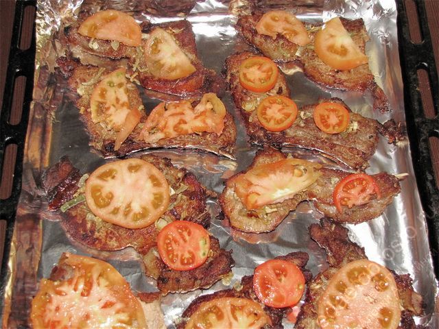 Разложить нарезанные помидоры по луку с мясом