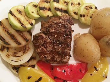 фото вкусного стейка из говядины с гарниром из овощей на тарелке