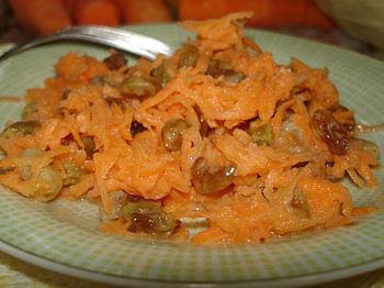 фото вкусного салата из свежей моркови с изюмом на тарелке