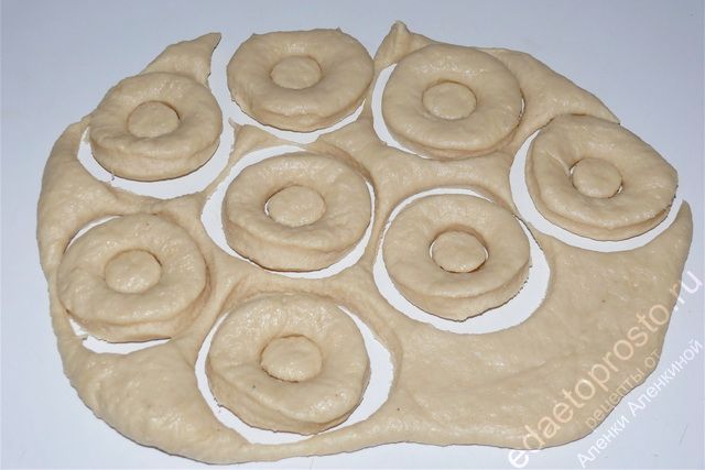 Раскатываем тонкое тесто и вырезаем из него колечки, пошаговое фото приготовления домашних пончиков