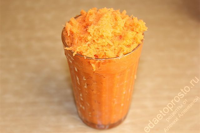 Натертую морковь уплотнить в стакане, выделившийся морковный сок слить