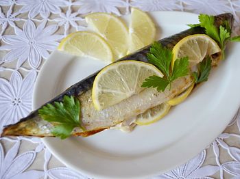 фото вкусной рыбы в фольге на тарелке с лимоном