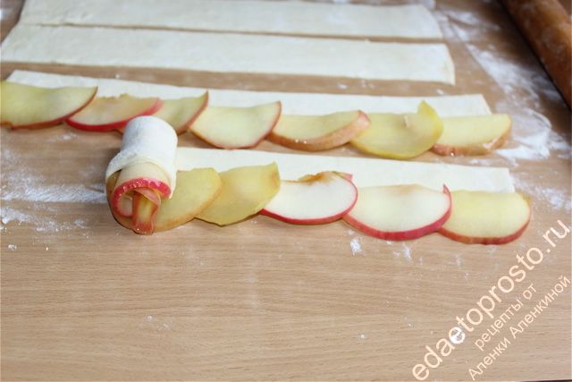 слоеное тесто с яблоками необходимо плотно скрутить в виде рулета