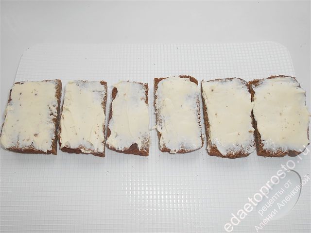 На хлеб намазываем сливочное масло и немного его подсаливаем, пошаговое фото приготовления бутербродов со шпротами