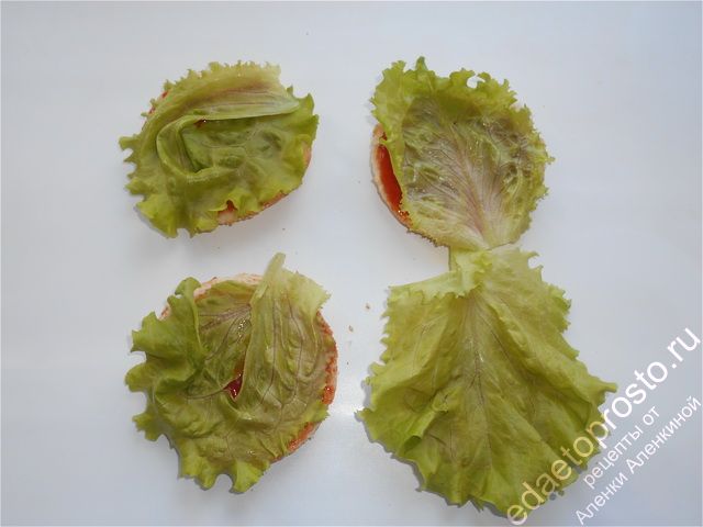 На нижнюю часть половинки булочки кладем лист салата