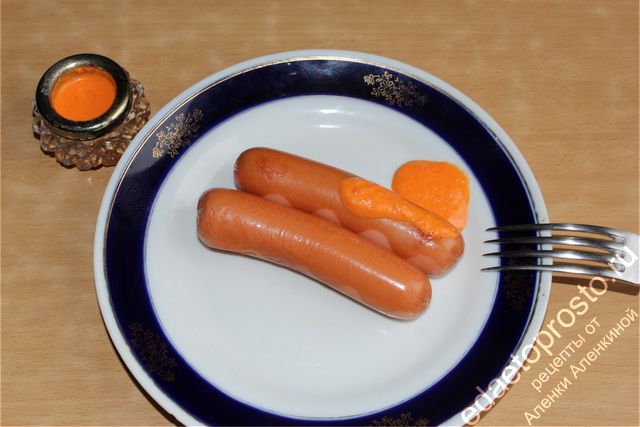 Острая аджика с сосисками на тарелке фото