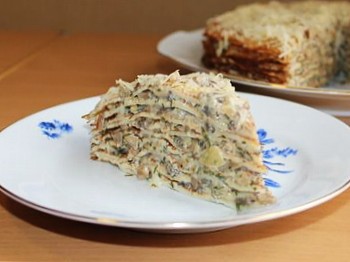 на фото вкусного закусочного блинного торта с грибной начинкой на тарелке