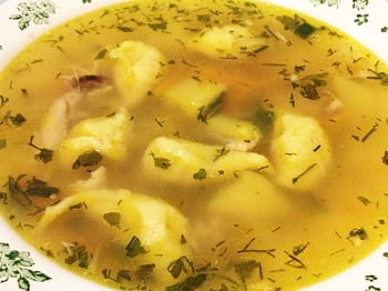 вкусный суп с клецками на курином бульоне в тарелке